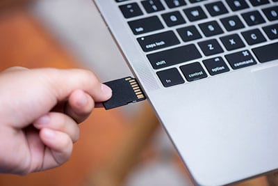 Hand inserting an SD card into the PC